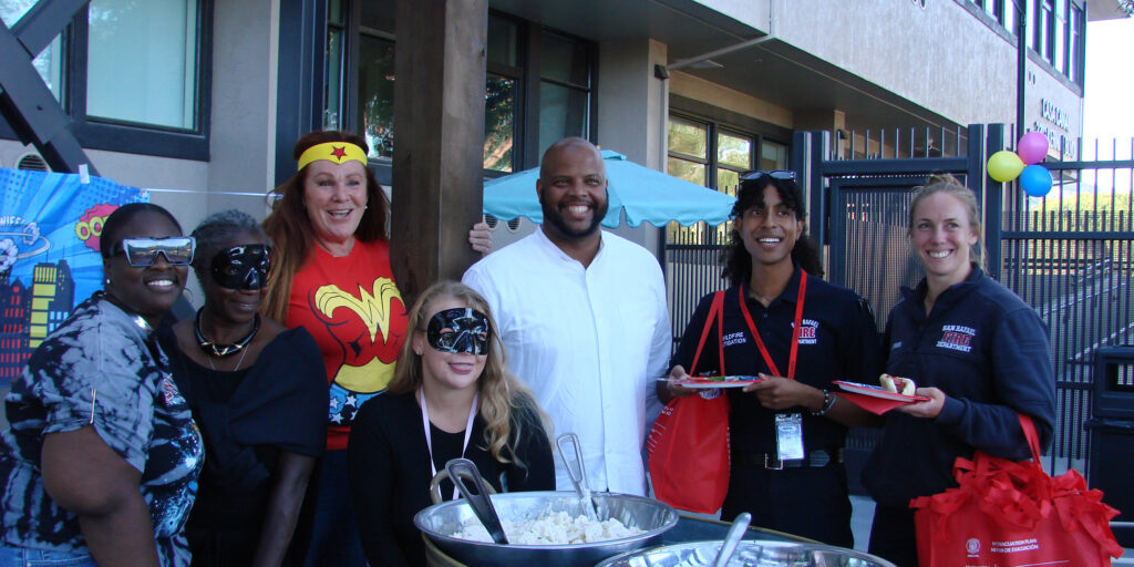 group of people smiling; some dressed as superheroes
